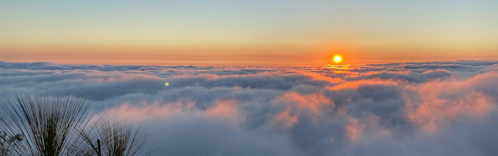 the sun is setting over the clouds in the sky
